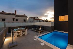un patio all'ultimo piano con piscina e tavolo di Casa Brave by Briskva a Funtana Altre 34 foto