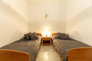 a bedroom with two beds and a night stand with a lamp at House Marija in Korčula