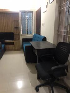 ブバネーシュワルにあるDDM Avenueのソファ、テーブル、椅子が備わる客室です。