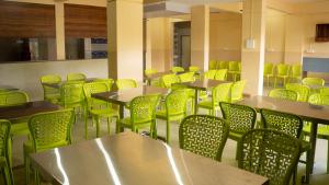 a cafeteria filled with tables and yellow chairs at Punekar Bhavan in Akalkot