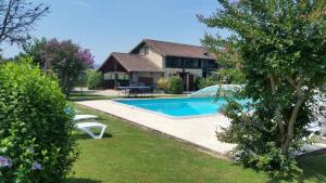 a house with a swimming pool in a yard at Logis Gascons in Saint-Justin
