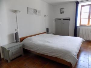 a bedroom with a white bed and a window at Logis Gascons in Saint-Justin