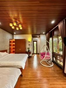 a bedroom with two beds and a swing at Vườn Trà HomeStay Măng Đen in Kon Von Kla