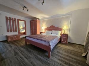 a bedroom with a bed with a large headboard at Casa Raduly - Apartament Demisol in Sibiu