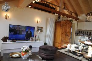 een woonkamer met een tv aan de muur bij Alpen-suite in Riezlern