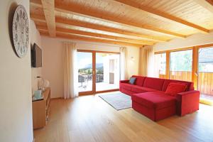 a living room with a red couch and a large window at Aurturist Badia in Badia