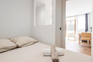 a white bedroom with a bed with towels on it at Margot in Beausoleil