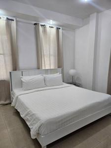 a white bedroom with a large white bed with white pillows at Happy Villa in Choengtalay in Laguna Phuket +23 photos