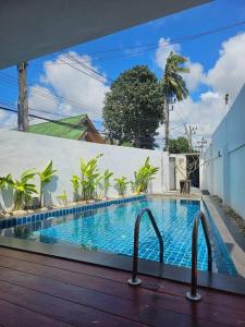 a swimming pool in the middle of a house at Happy Villa in Choengtalay in Laguna Phuket