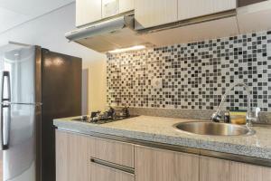 a kitchen with a sink and a refrigerator at Comfortable and Nice Studio Room Apartement at H Residence By Travelio in Jakarta