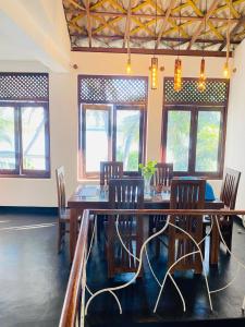 a dining room with wooden tables and chairs and windows at Lake Duwa Hotel in Ambalangoda +43 photos