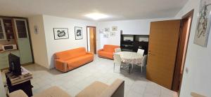 una sala de estar con una silla naranja y una mesa en Villa Pierpaola, en Castelsardo