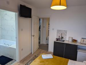 a kitchen with a sink and a tub in a room at Blok 3 -Jacuzzi Suites, Apartment & Ensuite Rooms in Blackpool +136 photos