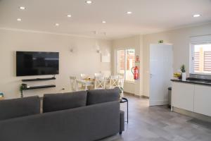 a living room with a couch and a dining room at Villa ELTAEL - Miguel House - Warm Pool until 1 November - Facilities for disabled guests in Manta Rota