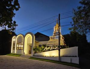 a church lit up at night with a building at ArtHostel At Sukhothai in Sukhothai