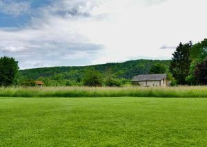 an open field with an old house in the distance at La Forge Tranquille in Heudreville-sur-Eure