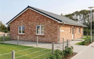 a brick building with a fence in front of it at Beautiful Home In Dagebüll With Sauna in Dagebüll