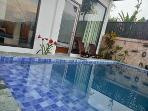 a swimming pool in front of a house at The Bunut Villas in Kubupenlokan +24 photos