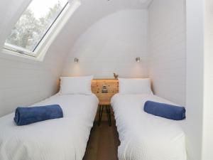 two beds in a small room with a window at Leadon View Oak in Newent