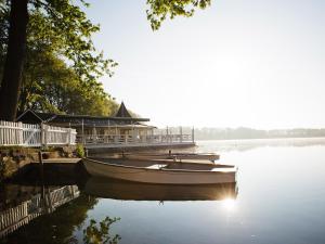 una barca seduta in acqua accanto a un molo di Bokel-Mühle am See a Bokel