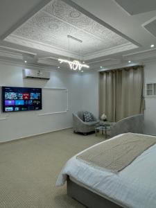 a bedroom with a bed and a tv on the wall at نزل العلا in AlUla