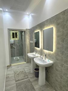 a bathroom with two sinks and a shower at نزل العلا in AlUla
