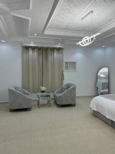a bedroom with a bed and two couches and a bed and a table at نزل العلا in AlUla