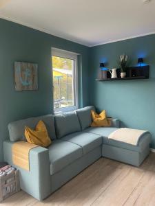 a living room with a blue couch with yellow pillows at Frohes Wochenende 22 in Boltenhagen