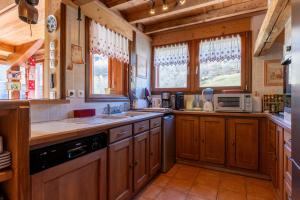 a kitchen with wooden cabinets and a microwave at Le Genepi les Menuires Val Thorens in Praranger +24 photos