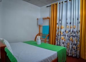 a bedroom with a bed with a green and yellow curtain at Nethu Villa Dodanduwa in Dodanduwa +13 photos
