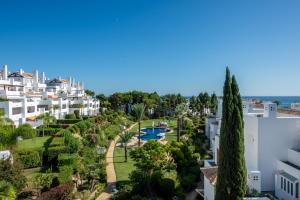 an aerial view of a resort with a pool and trees at Palm Beach Frontline Penthouse in Marbella