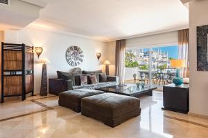 a living room with a couch and a table at Palm Beach Frontline Penthouse in Marbella +22 photos