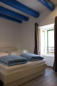 uma cama com duas almofadas num quarto com uma janela em Centar Vodice Apartmani em Vodice