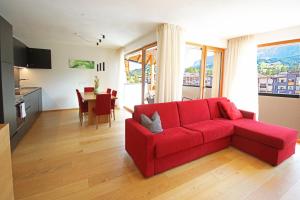 a living room with a red couch and a kitchen at Aurturist Badia in Badia +9 photos