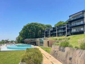 an apartment building with a swimming pool in a yard at Monoambiente Seminario Suites in Yerba Buena