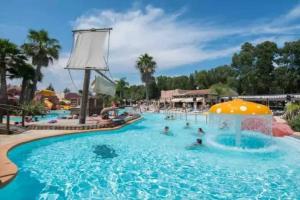 a group of people in a swimming pool at a resort at Camping 4 étoiles - Parc aquatique - eebaha in Hyères +15 photos