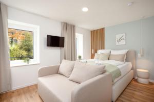a living room with a couch and a bed at DWELLSTAY - City Apartments Fulda in Fulda +13 photos