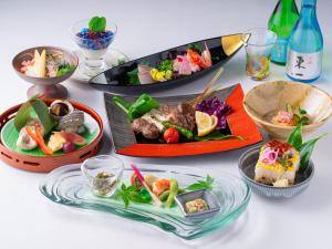 a table with plates of food and bowls of food at Hotel New Otani Saga in Saga