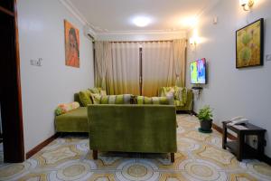 Una sala de estar con un sofá y un televisor. en Crystal Apartments Entebbe Uganda Next to UN Base, en Entebbe