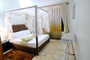 a bedroom with a bed with a canopy at Crystal Apartments Entebbe Uganda Next to UN Base in Entebbe