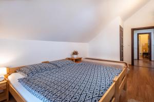 a bedroom with a bed with a blue and white comforter at Private holiday house Vivendi in Liptovský Mikuláš