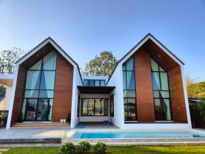 a house with a pool in front of it at ASTRID PoolVilla KhaoYai in Pak Chong
