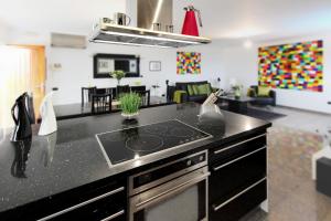 eine Küche mit einer schwarzen Arbeitsplatte und einem Herd in der Unterkunft Casa Business Finca Alcala in Alcalá