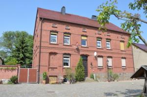 a large red brick building with a lot of windows at Ferienwohnungen Bunge in Krostitz