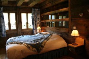 ein Schlafzimmer mit einem Bett, zwei Lampen und Fenstern in der Unterkunft La ferme des Fontany in Samoëns