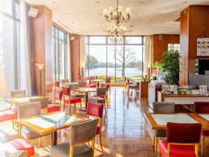 a restaurant with tables and chairs and a chandelier at Hotel New Otani Saga in Saga +118 photos