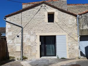 a stone building with a garage and a door at Love room avec spa privatif in Ruelle-sur-Touvre