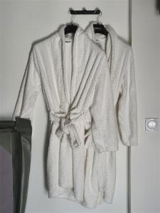 a robe hanging on a rack in a bathroom at Love room avec spa privatif in Ruelle-sur-Touvre