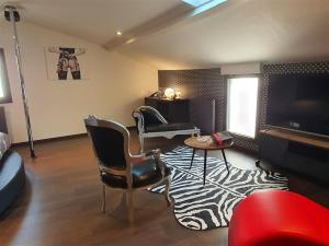 a living room with two chairs and a television at Love room avec spa privatif in Ruelle-sur-Touvre