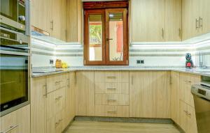 a kitchen with wooden cabinets and a window at 4 Bedroom Gorgeous Home In Lousame in Lousame